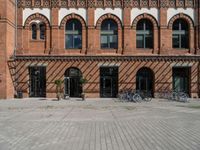 a large building has a brick front and front with bicycles parked in front of the window