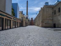 the sidewalk is paved with stones and has a bench in front of it, with no people inside