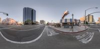 a big fish eye looking photo shows people walking on a street corner in a city