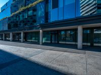 the view of an outside building with large windows from a low angle to the side of the street