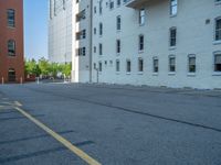 a street with a building near the building in the middle and on the left of which is a parking lot, as shown in this photo