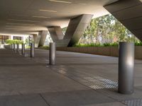 there are many steel poles in this courtyard area with tall buildings and trees around them