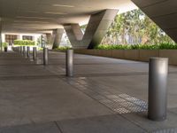 there are many steel poles in this courtyard area with tall buildings and trees around them