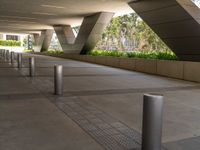 there are many steel poles in this courtyard area with tall buildings and trees around them