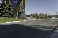 a traffic light on the street near a building and trees in the foreground of a paved city street