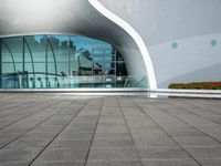 the outside side of a building with a pool and walkway, with a person standing on either side