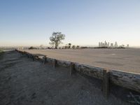 the large concrete bench is positioned on top of a cement wall with a city view in the distance