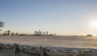 the large concrete bench is positioned on top of a cement wall with a city view in the distance