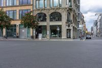 an empty street in front of some buildings on a rainy day with clouds in the sky