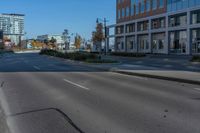 a empty street in front of a building in the city of a large city with many trees