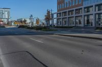 a empty street in front of a building in the city of a large city with many trees