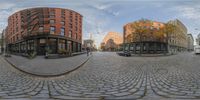 a fish eye view shows an urban city with lots of buildings and a brick road