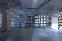 a large room with white pipes and metal stairs and a large window behind them in the ceiling