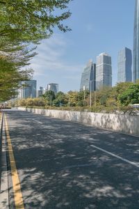 a city street with lots of tall buildings and trees around it and the sidewalks are empty