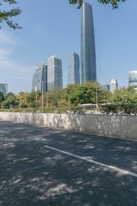 a city street with lots of tall buildings and trees around it and the sidewalks are empty