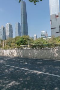 a city street with lots of tall buildings and trees around it and the sidewalks are empty