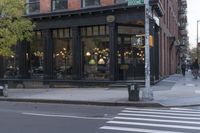 an intersection of a cross walk and store in an urban city area on the corner of the street