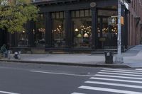 an intersection of a cross walk and store in an urban city area on the corner of the street