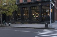 an intersection of a cross walk and store in an urban city area on the corner of the street