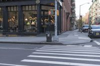 an intersection of a cross walk and store in an urban city area on the corner of the street