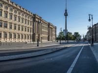 a street light next to an empty road in front of a building with a traffic light on top of it