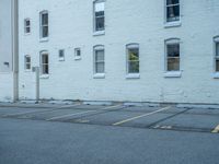 a street with a building near the building in the middle and on the left of which is a parking lot, as shown in this photo