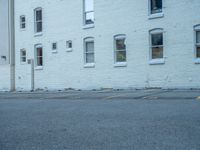 a street with a building near the building in the middle and on the left of which is a parking lot, as shown in this photo