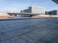 a skateboard sits outside a concrete structure that is next to a street area with a bench