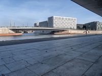 a skateboard sits outside a concrete structure that is next to a street area with a bench