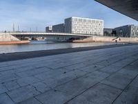 a skateboard sits outside a concrete structure that is next to a street area with a bench