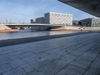 a skateboard sits outside a concrete structure that is next to a street area with a bench