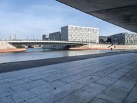 a skateboard sits outside a concrete structure that is next to a street area with a bench