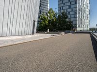 the man rides a skateboard on the road outside a city building next to it