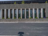 a building with a logo painted on the side near a street that has a sidewalk next to it