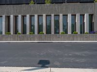 a building with a logo painted on the side near a street that has a sidewalk next to it