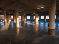 an empty building filled with lots of windows and pillars in the middle of the room