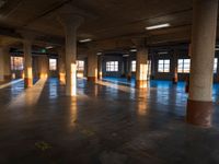 an empty building filled with lots of windows and pillars in the middle of the room