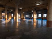 an empty building filled with lots of windows and pillars in the middle of the room