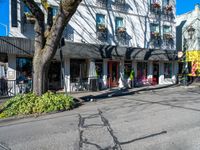 a shadow made into the street with bikes leaning against buildings and a man on a bicycle