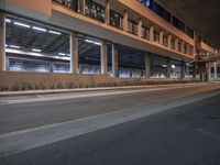 the view is at night from outside the building, showing the street and parking area