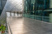 view of large building near walkway and a bench in front of it that is surrounded by metal