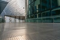 view of large building near walkway and a bench in front of it that is surrounded by metal