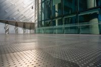 view of large building near walkway and a bench in front of it that is surrounded by metal