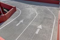 a large parking garage with no windows in it and some white arrows on the street