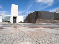 the concretes in front of the building are empty and have different shapes and textures