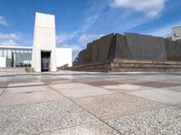 the concretes in front of the building are empty and have different shapes and textures