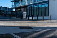 the empty walkway of an urban city plaza has brick and metal poles for the fire hydrant