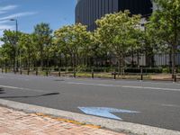 empty road with white lines on the streets of city area against cloudy blue sky on a sunny day