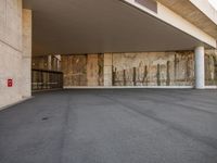 the entrance to a building with concrete walls and concrete flooring, as seen from below