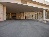 the entrance to a building with concrete walls and concrete flooring, as seen from below